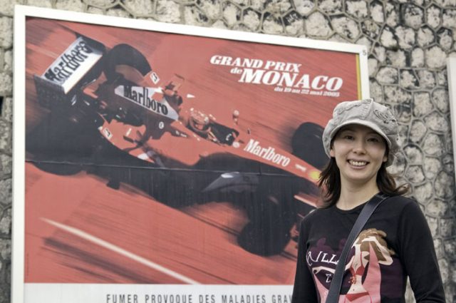 モンテカルロ市内で大好きなフェラーリの看板の前で我が女王陛下。